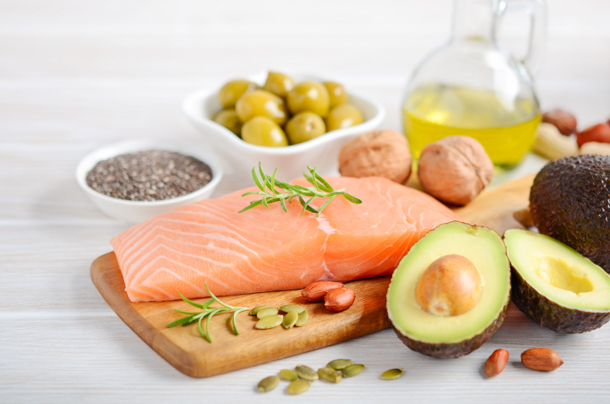 Ausgewogene Lebensmittel wie Lachs, Avocado, Nüsse und Olivenöl